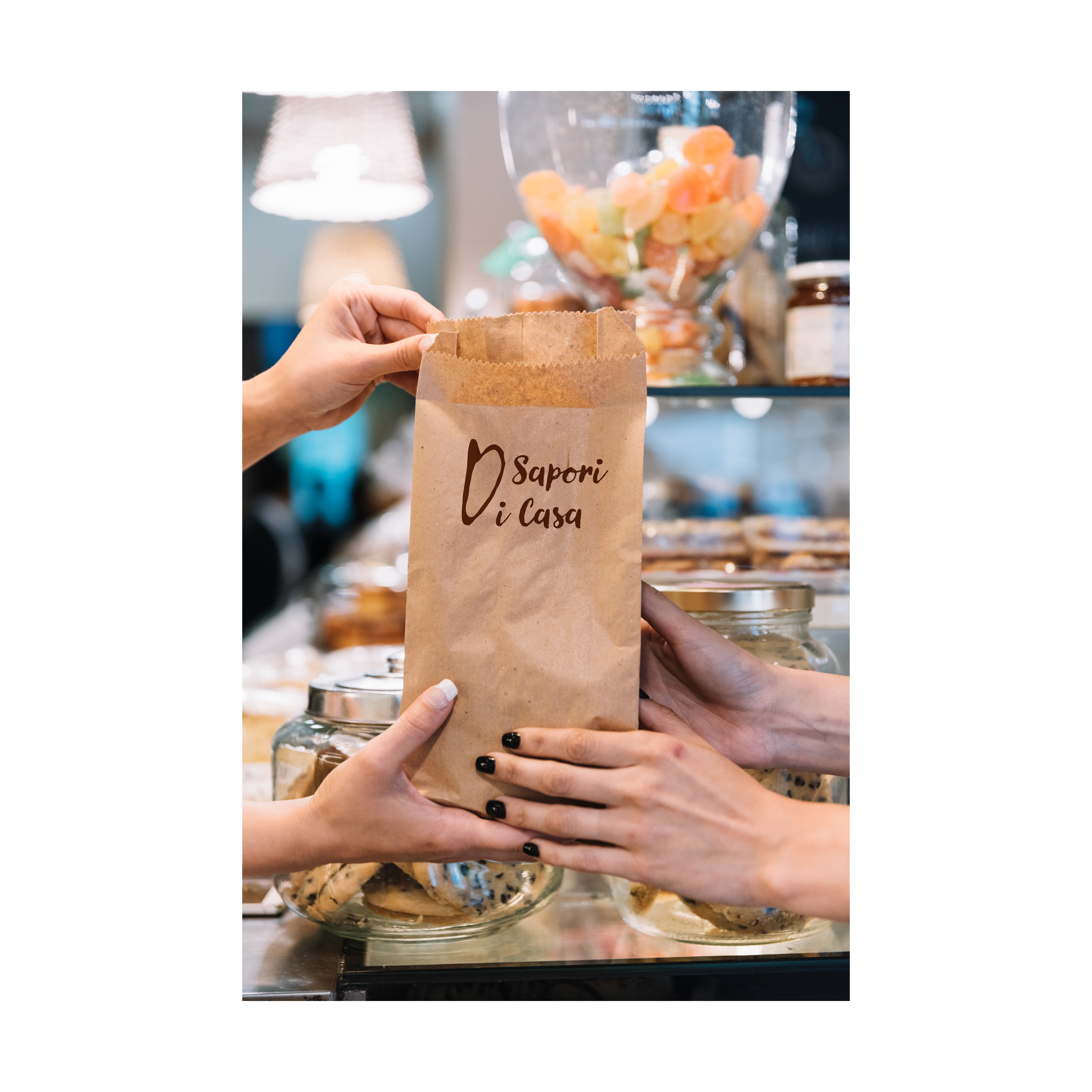 Due mani che si passano un sacchetto di carta brandizzato 'Sapori Di Carta'